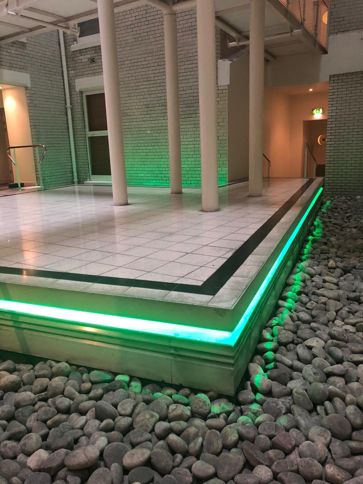 Indoor LED lighting installation under tiled platform for modern home interior design by U & O Electrical in Manchester
